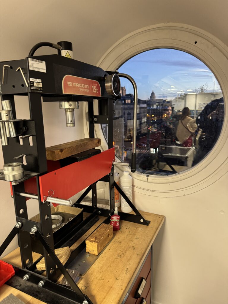  - Une presse hydraulique dans l'atelier de Wandercraft, avec vue sur les toits de Paris.