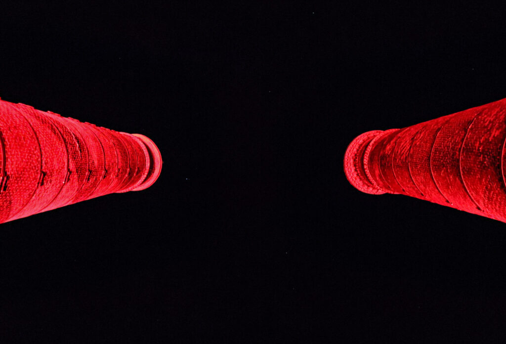  - Depuis la passerelle reliant les deux cheminées de l'ancienne manufacture, dans l'axe de ces cylindre de brique éclairés de rouge, j'ai retrouvé la silhouette de canons dressés, menaçants, ramenant le spectateur à l’infiniment petit. Ce ressenti fait écho à l’impuissance de l’Humain face à une usine qui a fabriqué des armes pendant près d'un siècle et demi. 