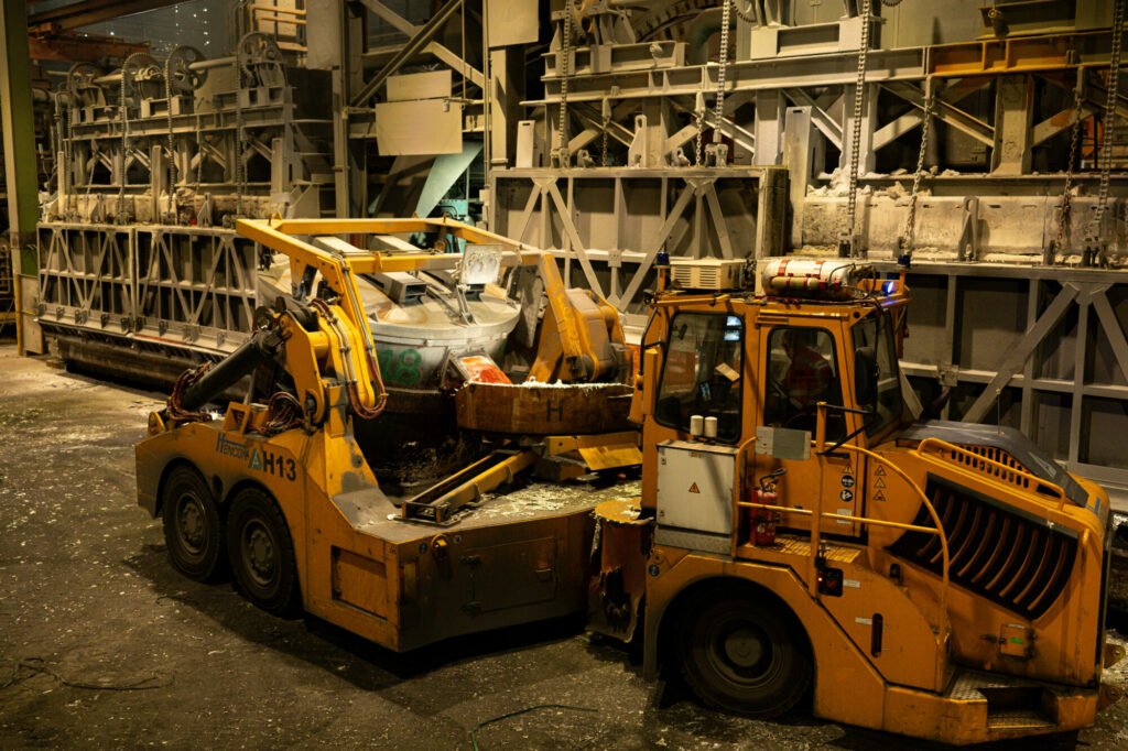 TomTOM - Dans la lumière des cuves d'électrolyse d'Aluminium Dunkerque, une poche de métal en fusion poursuit son parcours vers les étapes de transformation. Derrière cette scène spectaculaire se cachent des équipements de manutention de haute précision, conçus pour garantir sécurité, fiabilité et performance. Une image qui témoigne de l'innovation au service d'une production d'aluminium toujours plus efficace et responsable.