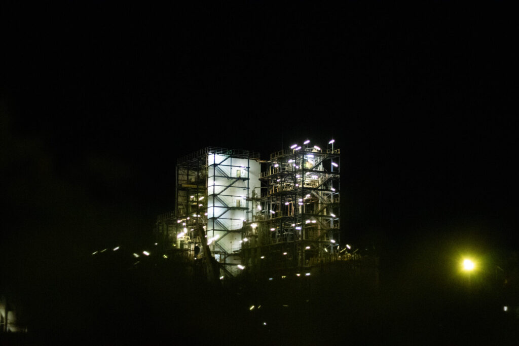  - Idées lumineuses - Série “D’un monde à l’autre”, explorant le chemin de l'innovation. Centre de Recherche Rhône-Alpes du groupe Arkema, pôle majeur d’innovation (mobilité propre, urbanisation durable, industrie 4.0…) situé à Pierre-Bénite. Photographie réalisée de nuit, depuis l’espace public. Septembre 2026. Par Clémence Fontan-Moret.