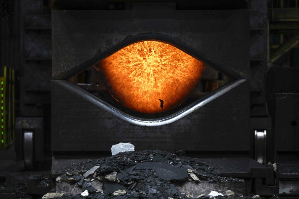  - Naissance d’un titan des mers.  Dans les ateliers d’Aubert & Duval, près de Saint-Étienne, naît l’une des pièces les plus critiques de la chaufferie nucléaire du futur porte-avions français : le coude de pompe primaire. Une pièce hors normes et innovante, conçue dans un alliage répondant à des contraintes extrêmes et nourrie du retour d’expérience des EPR civils. Sous la lumière des fours, presses et pinces semblent personnifiées. Ici se façonne une part de la souveraineté industrielle française.