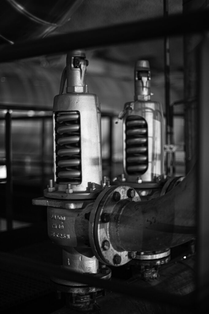  - La sélection de 3 photos livre une vision parcellaire de ce site industriel. Ces soupapes de sécurité, présentes dans les entrailles de la machinerie, rappellent avec force qu'elles ont été conçues pour durer – On ne peut qu’admirer l’esthétisme qui en résulte au milieu des écrans.